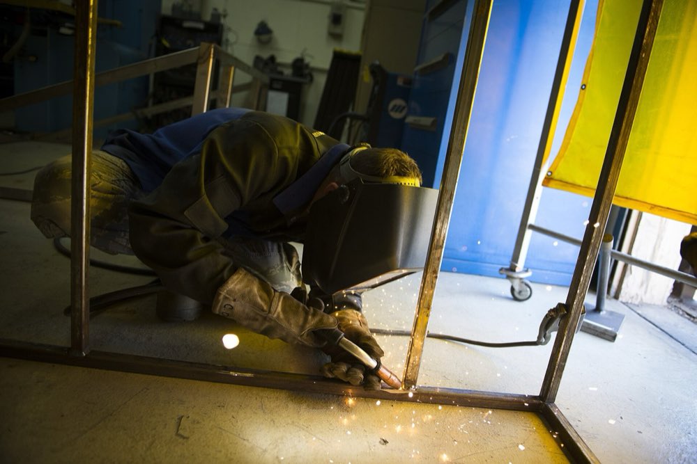 Welder at work in flame resistant leathers and coveralls