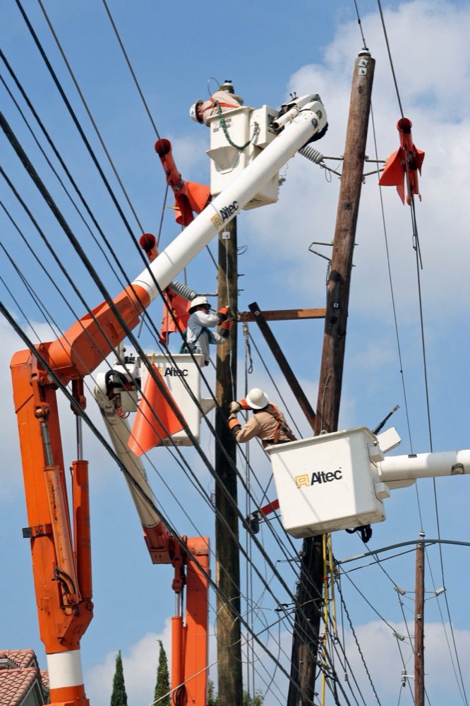 Utility line crew working from bucket trucks